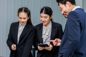 Millennial Asian Indian professional male businessmen female businesswomen employee staff colleagues in formal business suit standing discussing brainstorming working together with laptop computer