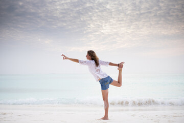 woman doing yoga by the sea pastel colors