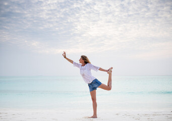 Fototapeta na wymiar woman doing yoga by the sea pastel colors
