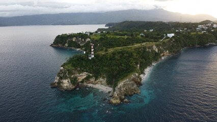 Fototapeta premium Aerial photography. View of the cape of a tropical island. Small lighthouse on the cliff.