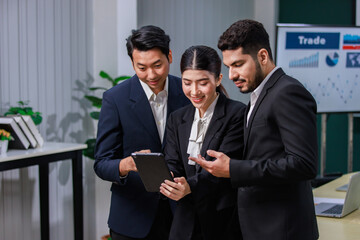 Millennial Asian professional successful female businesswoman employee in formal business suit stand smiling hold touchscreen tablet computer showing data information to male businessman colleagues