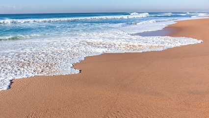 Fototapeta na wymiar Beach Sand Blue Ocean White Wave Water Wash Along Coastline