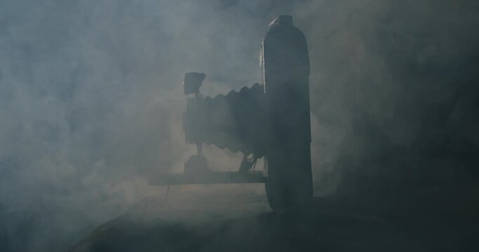 White smoke behind a very old vintage folding camera from 1910 in a dark room