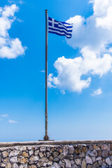 The blue and white flag of Greece with a clear sky with clouds on a sunny day