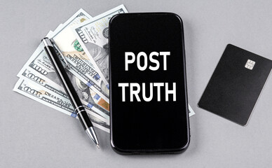 Credit card and text POST TRUTH on smartphone with dollars and pen. Business concept