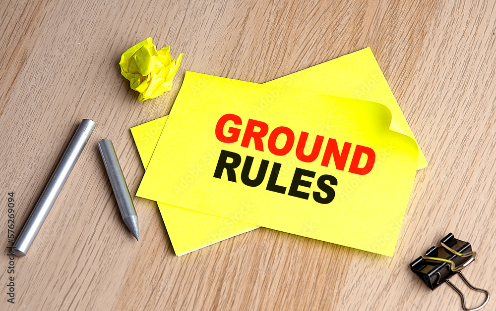 Poster ground rules written on a sticky on notebooks