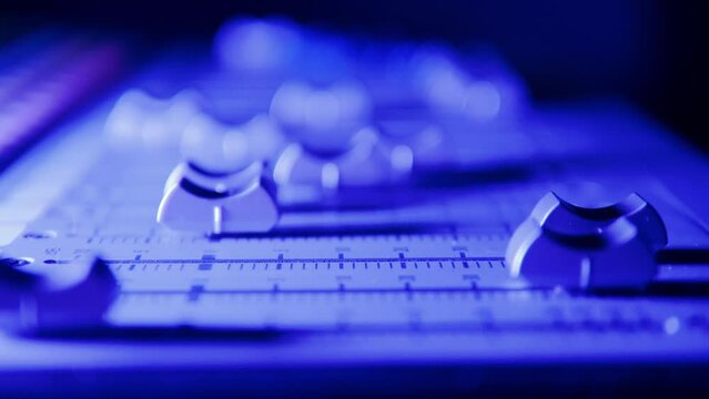 Close up of tumblers on the mixing board getting moved