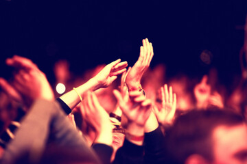 Reveling the atmosphere. An audience with hands raised at an outdoors festival.