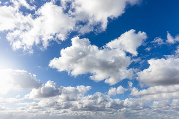 A blue sky with beautiful, white fluffy clouds as a background or texture
