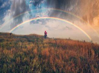 Woman Looking At Rainbow. rainbow over the autumn river. nature of Ukraine