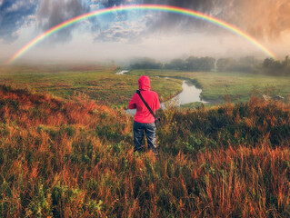 Woman Looking At Rainbow. rainbow over the autumn river. nature of Ukraine