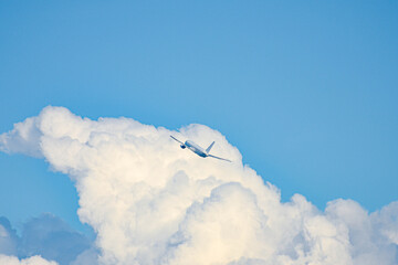離陸している旅客機と積乱雲