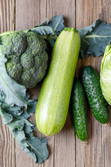 Green raw vegetables on wooden background. Healthy organic food.