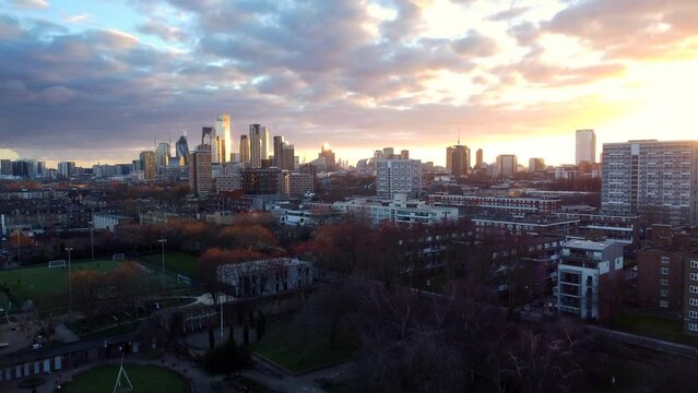 Drone shot flying over Haggerston Park with City of London in distance