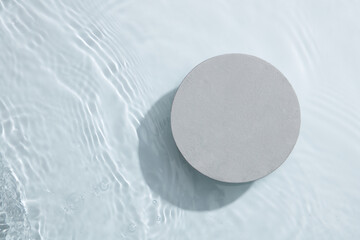 A gray circle podium isolated on the water surface background. Product promotion. Beauty cosmetic...
