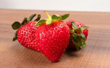 Fresh and Juicy beautiful organic strawberries on wooden background. Top view point.