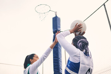 Sports, netball and black woman shooting ball in match for competition, exercise or practice. Training, wellness or players playing game for workout, exercising or competitive performance outdoors. © Azee Jacobs/peopleimages.com