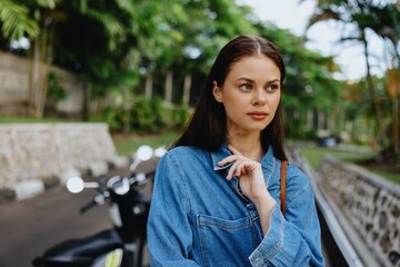 Portrait of a woman brunette smile with teeth walking outside against a backdrop of palm trees in the tropics, summer vacations and outdoor recreation, the carefree lifestyle of a freelance student.