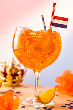 Summer coctail Aperol spritz in glass with Dutch event Kings day Koningsdag in background. National holiday in the Netherlands. 27 april