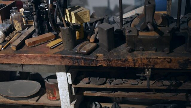 A vintage cobbler shoe making workshop with tools and footwear