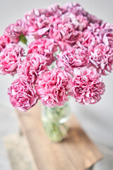 Beautiful pink carnation flowers in a vase on a table . Bouquet of light pink flower. Decoration of home. Wallpaper and background. fuchsia color - 576284261