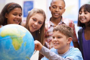 Here it is - Geography class. A group of pupils looking at a globe during geography class. © Mapodile/peopleimages.com