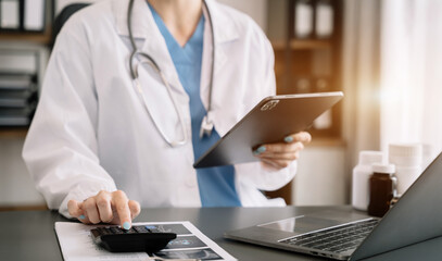 Doctor women use a service fee calculator to save money on health insurance, drug cost concept..
