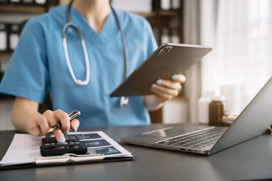 Doctor use a service fee calculator to save money on health insurance, drug cost concept.