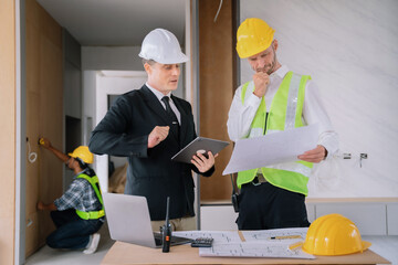 Person's engineer Hand Drawing Plan On Blue Print with architect equipment, Architects discussing at the table, team work and work flow construction concept.