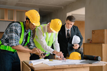 Working as a team architect and designer working on blueprint project of new apartments. Photo concept of work on technical drawings in construction site.