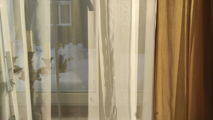 Curtain with tulle on the window. The interior of the room with draped curtains