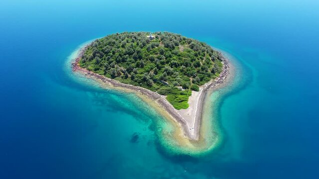 Aerial drone video of Strongili, a small islet in paradise complex volcanic islands of Lichadonisia in North Evia, Greece