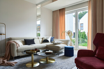 Creative living room interior composition with beige sofa, glass coffee table, carpet on the floor...