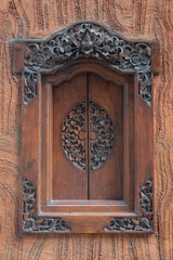 Balinese wood carved window with traditional local ornaments.