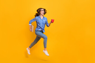 Fototapeta na wymiar Full size profile photo of amazed girl hold laptop coffee mug jump run empty space isolated on yellow color background
