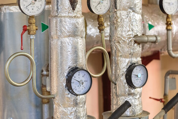Plumbing pipes with pressure gauges in the basement of a house
