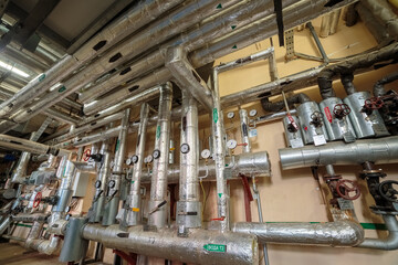 Industrial switching of heating pipes in the basement running along the walls and ceiling