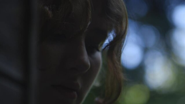 Cinematic close up young caucasian girl face with trees in background