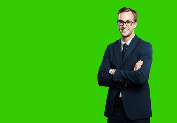 Obraz na płótnie Canvas Portrait of businessman in eye glasses, spectacles, black suit and tie, with crossed arms, green chroma key background. Business concept. Smiling man at studio picture. Copy space for ad.