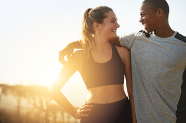 Keeping each other healthy and happy. Shot of a fit young couple working out together outdoors.