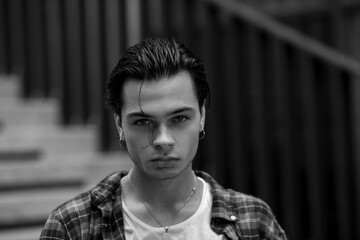 Handsome guy calmly and confidently looking at camera outdoors