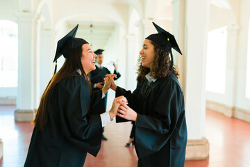 Cheerful young women laughing celebrating graduating