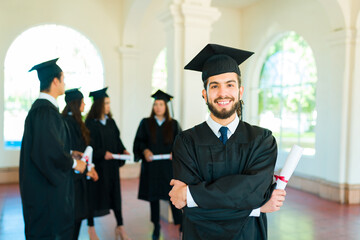 Hispanic man smiling with a graduation gown