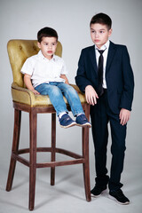 Two young brothers with high chair