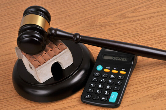Concept de vente aux enchères d'une maison avec un marteau de juge et une calculatrice