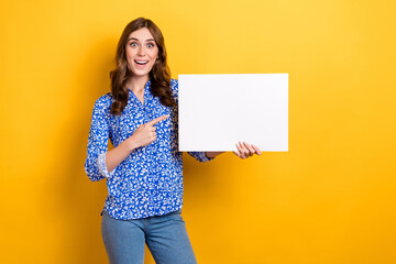 Obraz na płótnie Canvas Photo of excited funky lady wear print shirt showing finger white billboard empty space isolated yellow color background