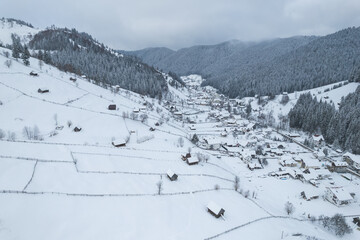 Fototapeta na wymiar Winter landscape in rural Transylvania. Snowy scene in the Romanian mountains
