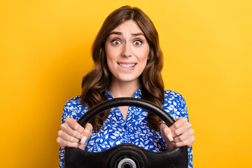 Photo of pretty nervous woman dressed blue blouse biting lip riding car isolated yellow color...