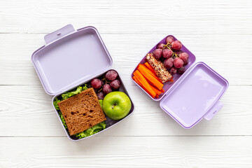 Healthy lunch boxes filled with fruits and vegetables, top view