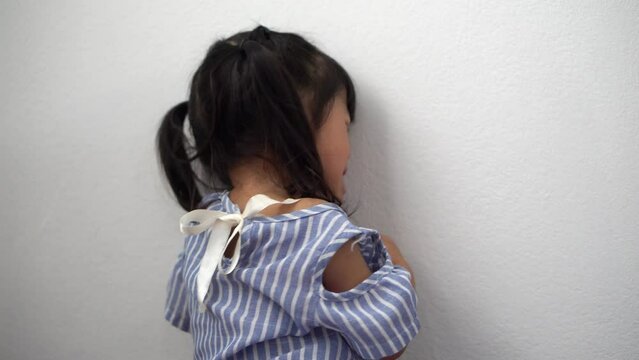 A Litter Asian girl sitting in room conner and crying after Punished by the blackout.